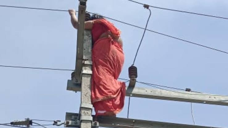 “Desperate Act: Woman Climbs Electric Pole Amidst Marital Discord Over Extramarital Affair”